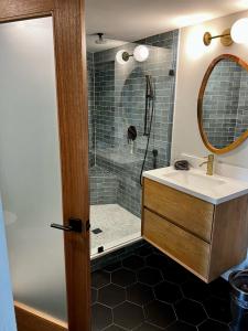 a bathroom with a shower with a sink and a mirror at NEW Modern apt w/pool & hot tub in nature in Thousand Oaks