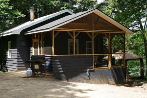 una pequeña casa negra con una gran ventana en Walker Lake Resort en Huntsville