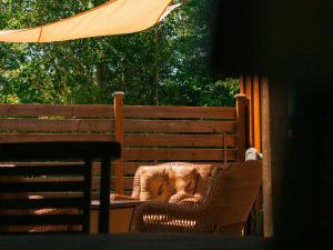 una silla de mimbre sentada en un porche con sombrilla en Chalet 8, en Val-David
