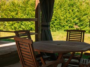 - une table en bois et 2 chaises sur une terrasse couverte dans l'établissement Chalet 8, à Val-David