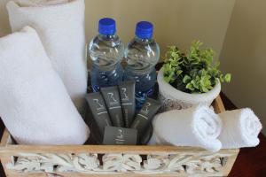 a shelf with two bottles of water and towels at Royal Guest House in Port Alfred