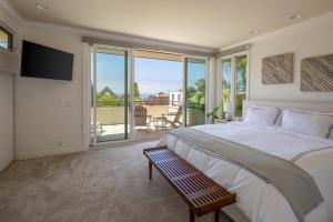 a bedroom with a large bed and a balcony at Ocean View Del Mar Beach Home w Jacuzzi in San Diego