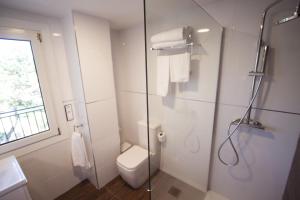 a bathroom with a toilet and a glass shower at Hotel Inffinit Sanxenxo in Sanxenxo