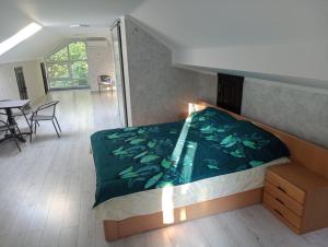 1 dormitorio con 1 cama, mesa y sillas en Cataleya Caffee en Rădăuţi