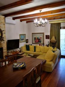 sala de estar con sofá amarillo y mesa en Villa Miro, en Golem