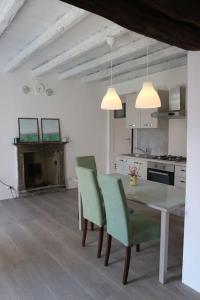 uma cozinha com uma mesa e cadeiras e uma lareira em Traditional Piazza Home/Balcony/ Private Garden em Cernobbio