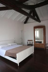 um quarto com uma grande cama branca e um espelho em Traditional Piazza Home/Balcony/ Private Garden em Cernobbio