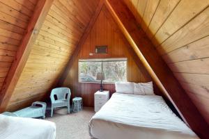 a bedroom with a bed and a window in a attic at Alford Family Lodge in Bass Lake