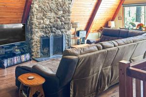a living room with a couch and a stone fireplace at Alford Family Lodge in Bass Lake