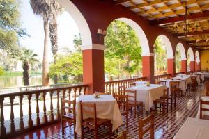 un restaurante con mesas y sillas en un balcón en DM Hoteles Mossone - Ica en Ica
