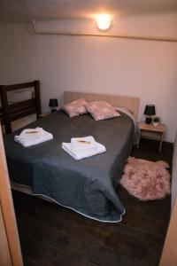 een slaapkamer met een bed met twee handdoeken erop bij Beer and caffe apartment in Subotica