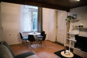 een woonkamer met een tafel en stoelen en een raam bij Beer and caffe apartment in Subotica