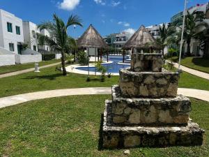 um monumento de pedra na relva perto de uma piscina em Casa con alberca y jardín en Cancún em Cancún