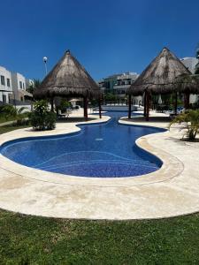 uma piscina com guarda-sóis num resort em Casa con alberca y jardín en Cancún em Cancún