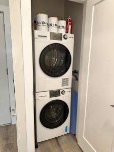 um micro-ondas e uma máquina de lavar e secar roupa num quarto em Home Haven, Walk to Little Italy & Wooster Square em New Haven