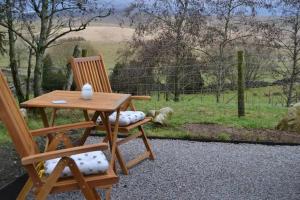 a wooden table and two chairs with a table at LetAway - The Hive Lodge at Ashes Farm in Settle