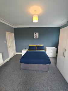 a bedroom with a bed with a blue wall at Spacious large room 001 in Nottingham