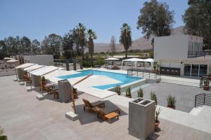 a pool with tables and chairs next to a building at DM Hoteles Moquegua in Moquegua