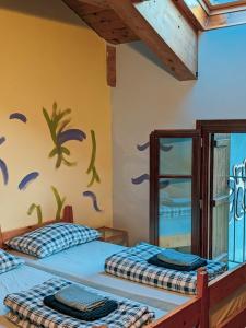 - 2 lits dans une chambre avec une fresque murale dans l'établissement Rifugio Aleve, à Castello