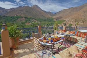 a balcony with a table with food on it at Riad Dar Omar in Imlil