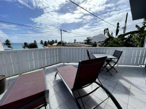 patio con mesa y sillas en el balcón en Studio à 80 mètres de la plage du Diamant en Le Diamant