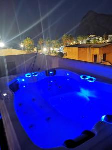 a blue hot tub on a balcony at night at MARE e Terra Holiday fronte mare in San Vito lo Capo