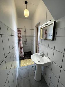 La salle de bains blanche est pourvue d'un lavabo et d'une douche. dans l'établissement Studio à 80 mètres de la plage du Diamant, au Diamant