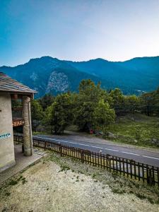 une route avec une clôture sur le côté d'une montagne dans l'établissement Rifugio Aleve, à Castello