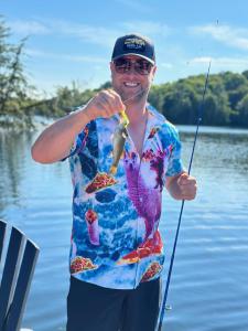 un uomo che tiene un pesce su due canne da pesca di Walker Lake Resort a Huntsville