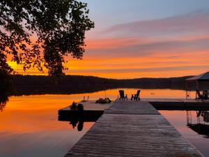 a dock on a lake with a sunset in the background at Walker Lake Resort in Huntsville