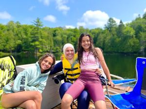 two girls and a woman sitting on a boat at Walker Lake Resort in Huntsville