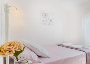 - un lit blanc avec un vase et une fleur dans l'établissement Apartman Legac 2 Nin, à Nin