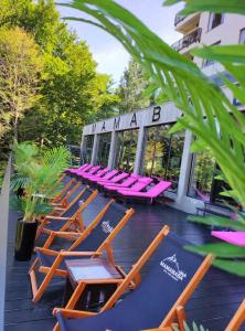a row of lounge chairs sitting on a patio at Kopaonik Milmari Spa and Wellness Wooden Horn S21 in Kopaonik