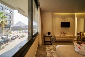 a bedroom with a large window with a view of a city at Gold's Pyramids Hotel in Cairo