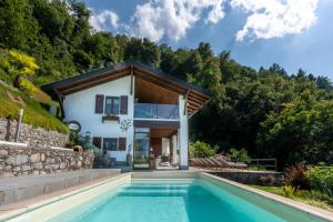 dom z basenem przed domem w obiekcie Villa Rosch w mieście Lezzeno