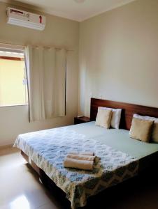 a bedroom with a large bed with two towels on it at Pouso Oliveira Casa com ar condicionado in São João Batista do Glória