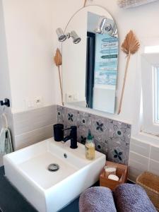 y baño con lavabo blanco y espejo. en Côte d'Opale - Maison Cocooning Classé 3 Étoiles en Marquise