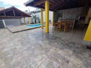 una casa y un patio con mesa y sillas en Pouso Oliveira Casa com ar condicionado en São João Batista do Glória