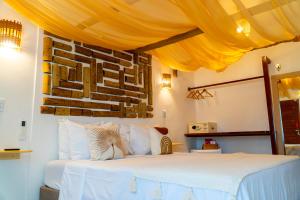 a bedroom with a white bed with a yellow canopy at Solarium de Gostoso in São Miguel do Gostoso