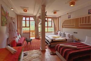 a bedroom with two beds and a living room at Riad Dar Omar in Imlil