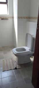 a bathroom with a white toilet in a room at Shawmut suites in Nakuru