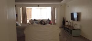 a living room with a couch and a large window at Shawmut suites in Nakuru