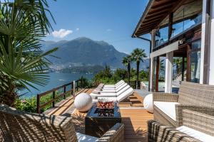 een patio met stoelen en uitzicht op het water bij Villa Rosch in Lezzeno