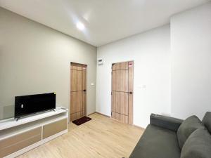 a living room with a couch and a flat screen tv at Phattharasaya Home in Udon Thani