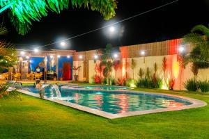 a swimming pool in a yard at night at Solarium de Gostoso in São Miguel do Gostoso