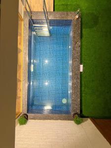 a blue shower in a room with green grass at Modern villa 4BR, Lawn & Mini Pool in Belagavi in Shāhāpur