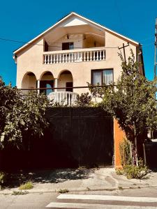 ein Haus mit einem schwarzen Zaun vor einem Haus in der Unterkunft Family Guesthouse - MACHARASHVILI in Tbilisi City