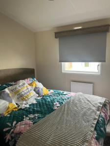 a bedroom with a bed with a book on it at Haggerston castle caravan rental. Annie's den in Beal
