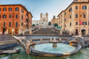 une fontaine au milieu d'une ville avec des bâtiments dans l'établissement RomeInSuite, à Rome
