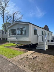 a white tiny house sitting on a lot at Haggerston castle caravan rental. Annie's den in Beal